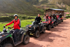 Group of tourists driving ATVs through Andean valleys toward Rainbow Mountain