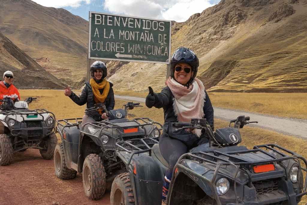 dventurers posing with ATVs near the colorful slopes of Vinicunca Mountain