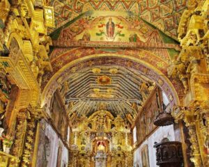 Interior of Andean Baroque church with golden altar in South Valley Cusco Peru