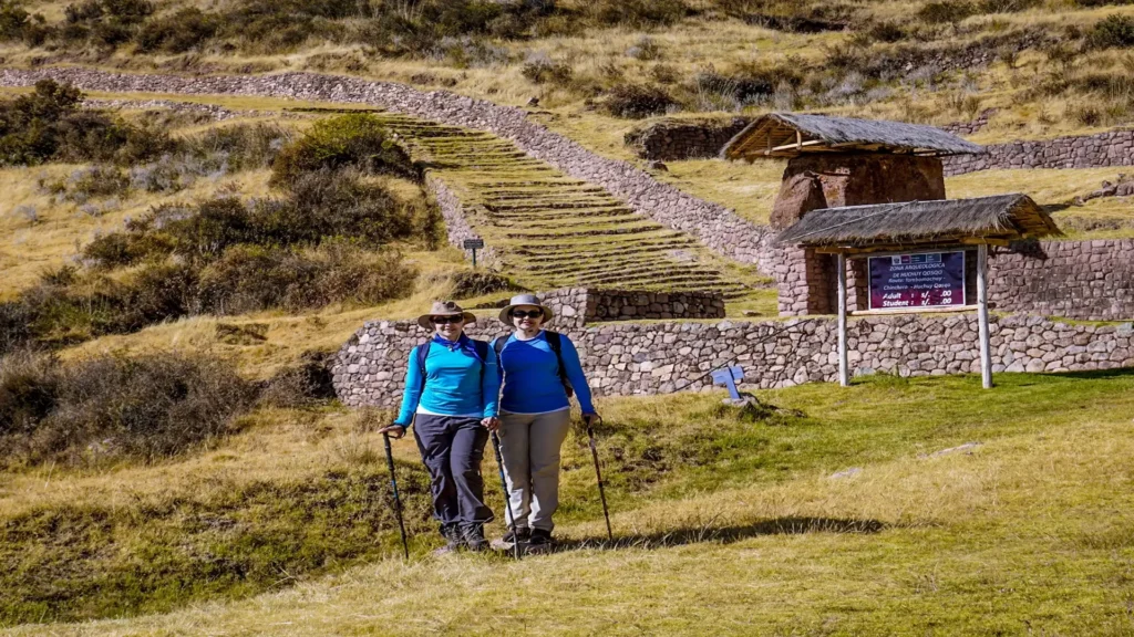 Hikers standing near Huchuy Qosqo archaeological site in the Sacred Valley during a trekking tour from Cusco, Peru.