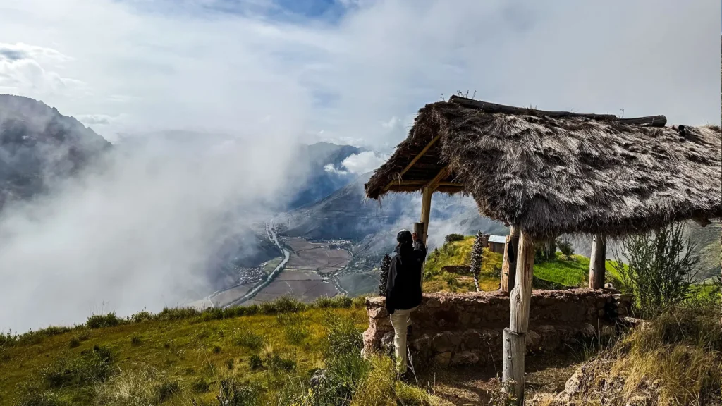 Traveler enjoying panoramic Sacred Valley views from Huchuy Qosqo viewpoint near Cusco, Peru.