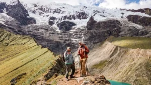 Hikers at the viewpoint of Humantay Lake with snow-capped mountains in the Peruvian Andes