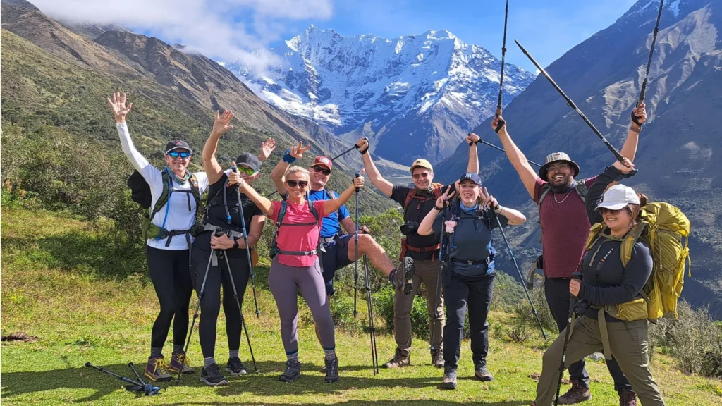 Group of trekkers celebrating on the Humantay Lake & Salkantay Pass Trek 2 Days with snowy Salkantay Mountain in the background.