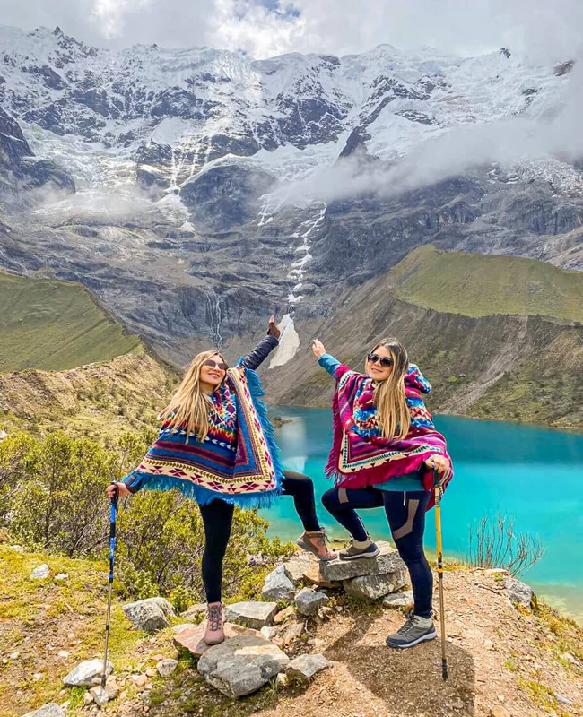 Travelers at Humantay Lake with turquoise water and snow-capped mountains in Peru