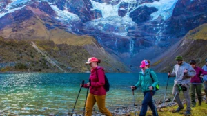 Group of hikers trekking along the shores of Humantay Lake in the Peruvian Andes