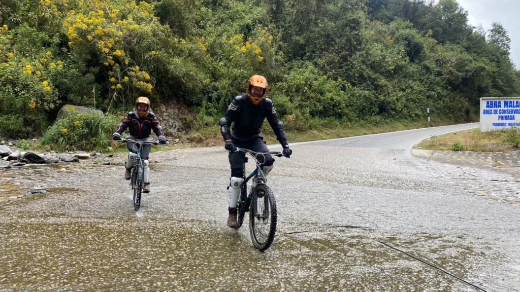 Travelers crossing a river by mountain bike during the Inca Jungle tour to Machu Picchu