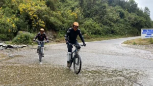 Travelers crossing a river by mountain bike during the Inca Jungle tour to Machu Picchu