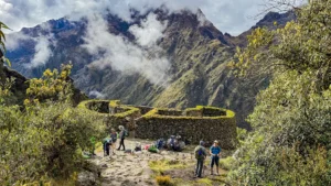Hiker admiring ancient Inca ruins along the Inca Trail Classic 4 Days route.