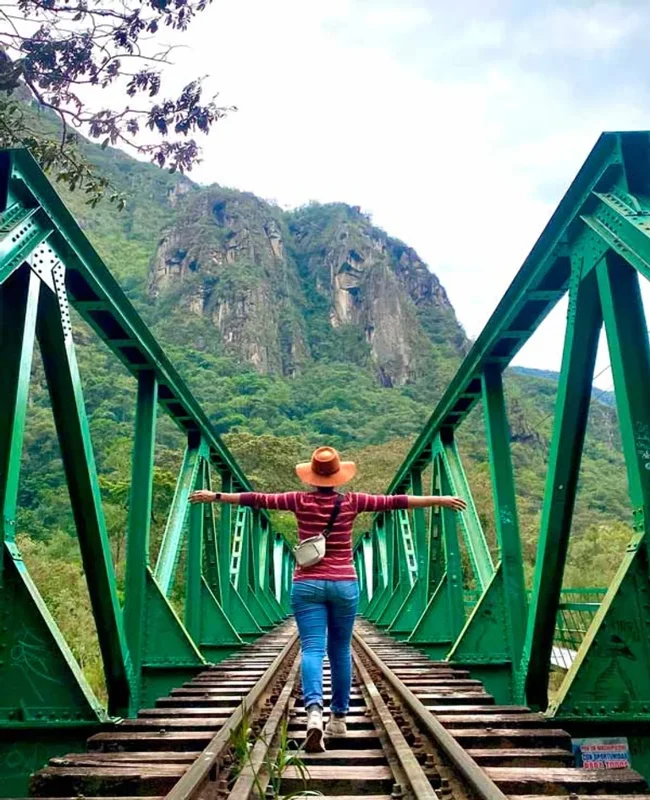 Traveler walking across the Hidroelectrica bridge on the Machu Picchu by Car route