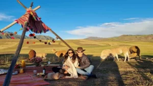 Couple enjoying a private Maras Moray Picnic Tour in the Sacred Valley with llamas and Andean landscape – Pacha Peru Explorers