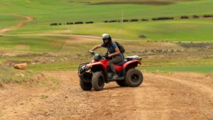 Traveler riding a red ATV during the Maras Moray ATV adventure in the Sacred Valley of Cusco, Peru.