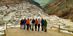 Group of travelers visiting the Maras Salt Mines in the Sacred Valley of Cusco, Peru.