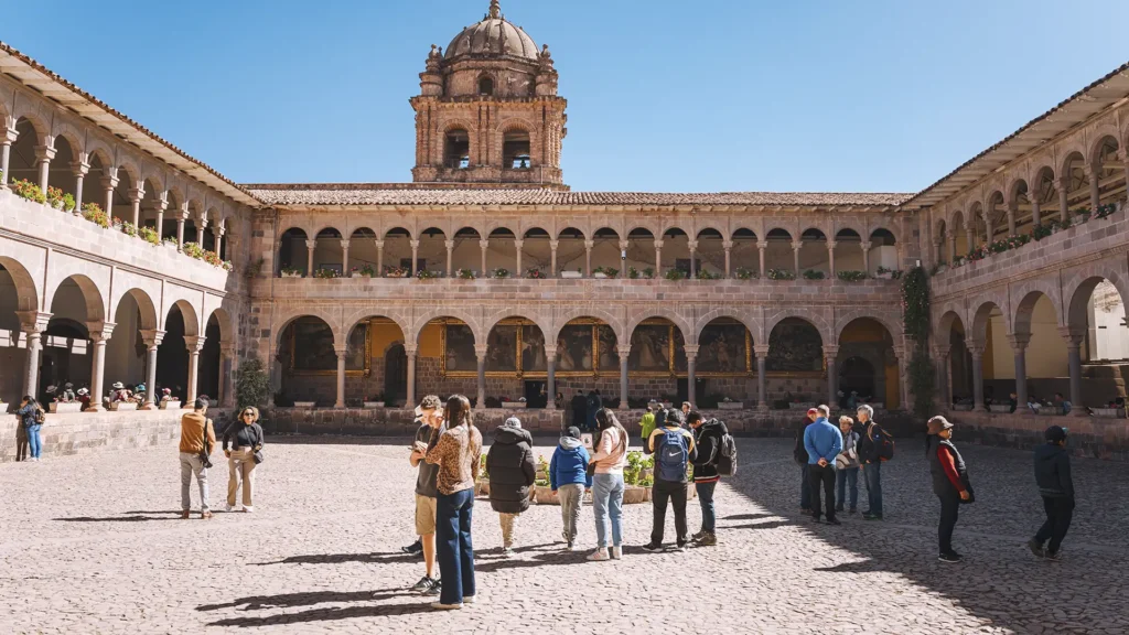 Visitors exploring Qorikancha Temple courtyard during a Cusco City Tour in Peru.