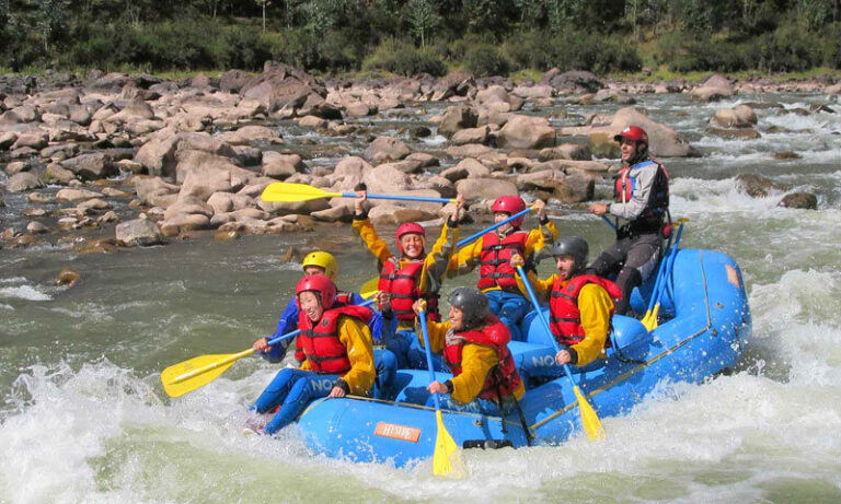Group of rafters paddling through white water rapids on the Vilcanota River near Cusco, Peru.