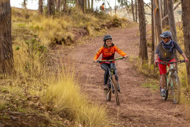 Two cyclists riding mountain bikes on a forest trail in Yuncaypata near Cusco, Peru.