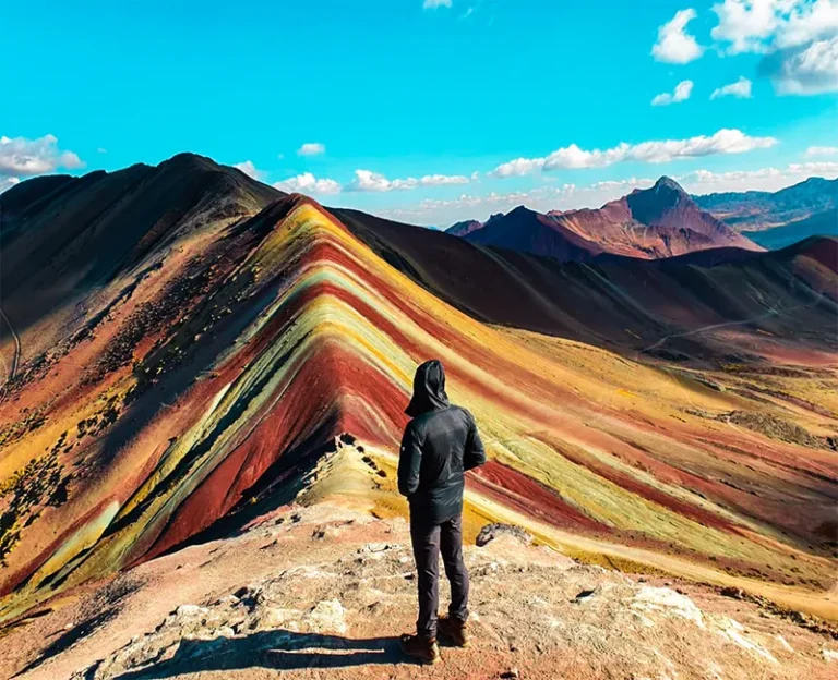 Hiker enjoying panoramic views at Rainbow Mountain Vinicunca in Peru