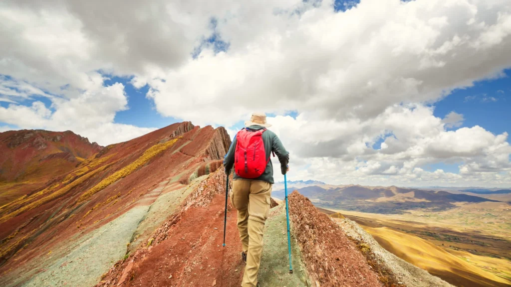 Hiker trekking to Rainbow Mountain Vinicunca with colorful Andes landscape