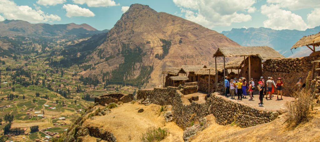 Tourists visiting Pisac Inca ruins overlooking the Sacred Valley in Cusco, Peru