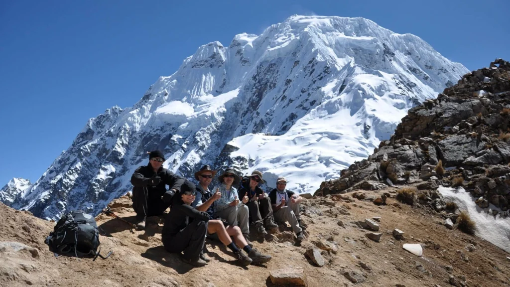 Group of trekkers resting at Salkantay Pass with the impressive snowy Salkantay Mountain in the background during the Humantay Lake & Salkantay Pass Trek 2 Days.
