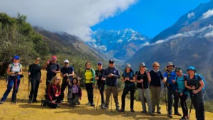 Group of hikers standing on the Salkantay Trek trail with snow-capped mountains behind them in the Peruvian Andes