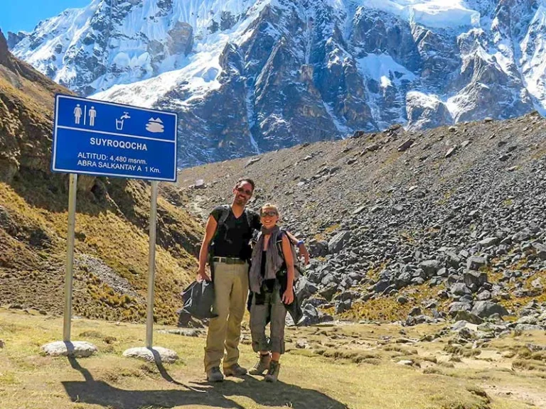 Two hikers standing at Suyroqocha with snowy Salkantay Mountain in the background during the Salkantay Trek 4 Days in Peru.