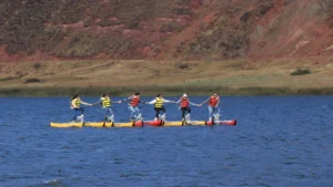 Group enjoying a water bike experience on a lake in Peru, riding floating bikes and wearing life jackets.