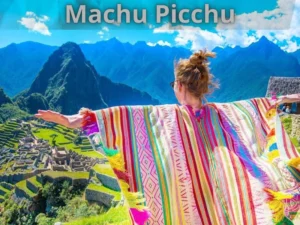 Traveler wearing traditional Andean poncho looking at Machu Picchu citadel and Huayna Picchu mountain in Cusco Peru