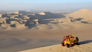 Dune buggy driving across the sand dunes of Huacachina desert in Ica Peru with tourists